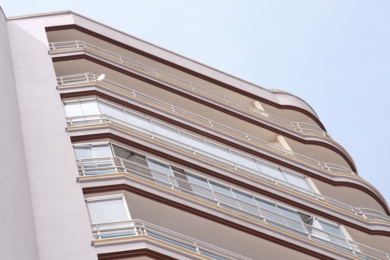 services-02 Low angle view of a modern apartment building in İzmir, showcasing residential urban architecture.